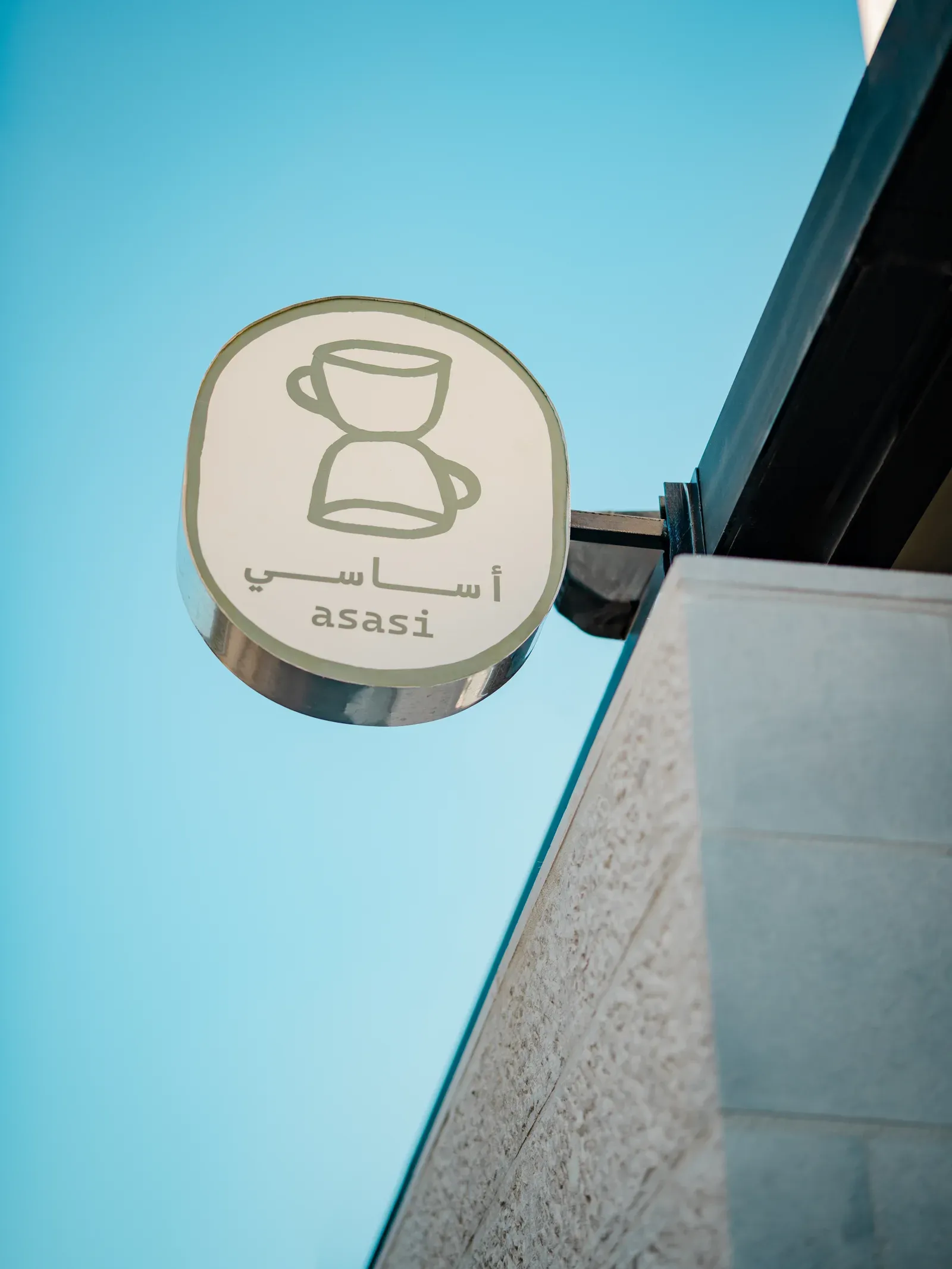Asasi Café’s round exterior sign against the blue sky