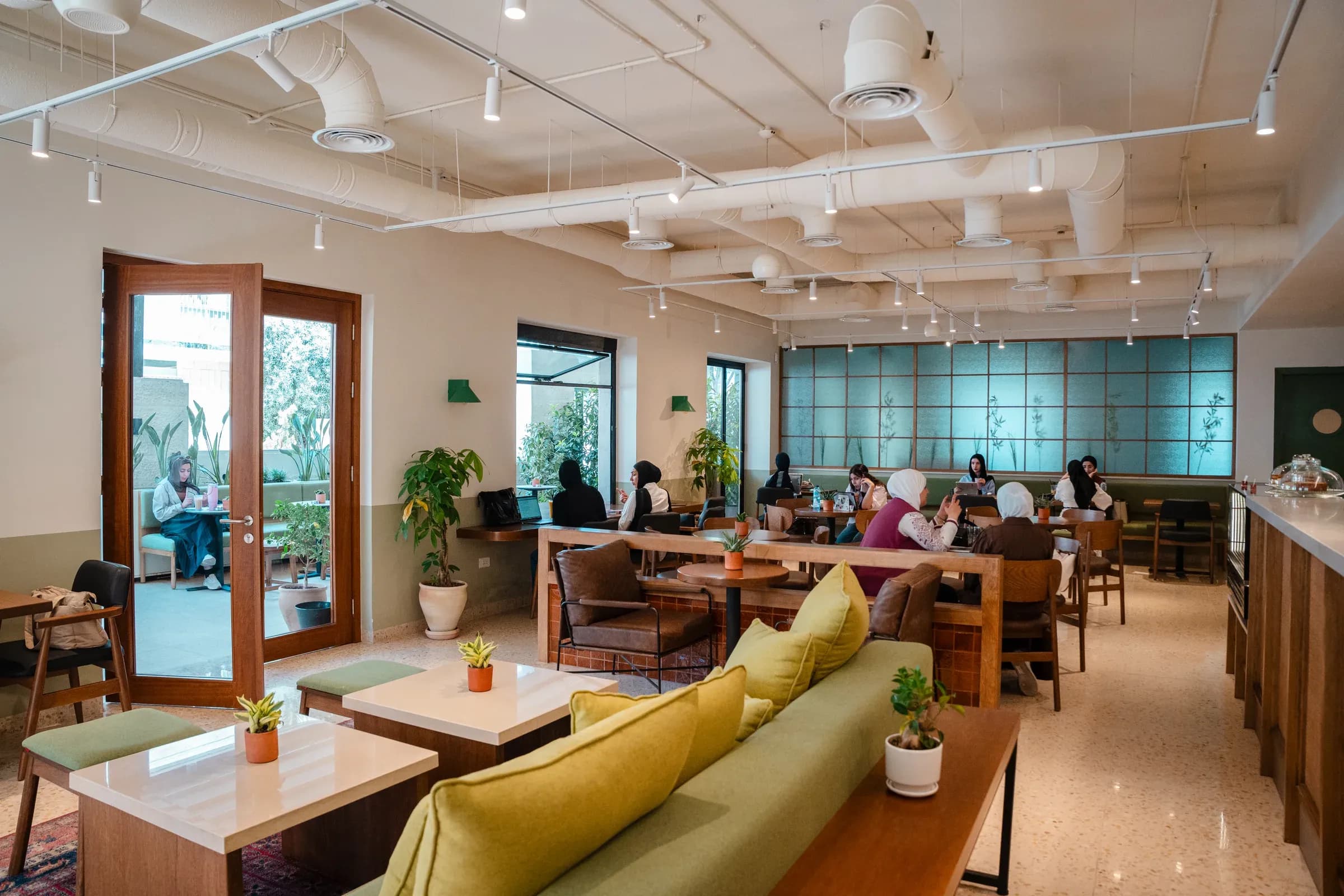 Asasi Café interior with timber furniture, green seating and the service counter