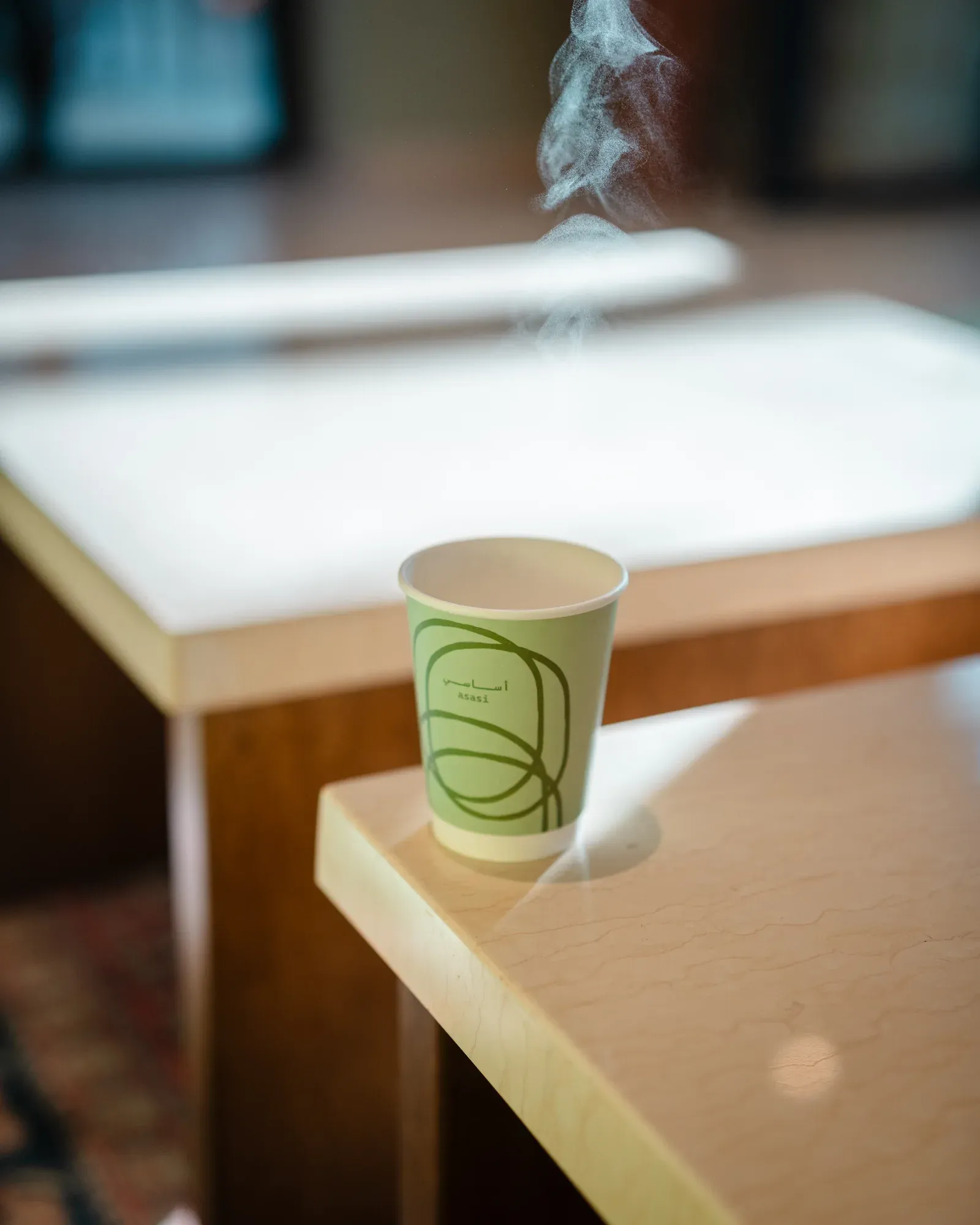 Asasi branded takeaway cup on a café table